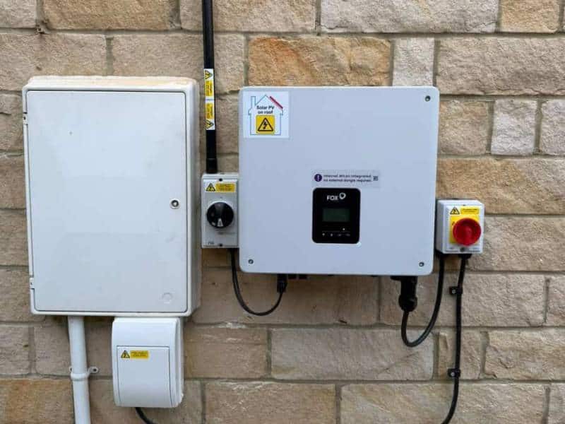 New solar PV installation with inverter fitted on an exterior wall in Manchester